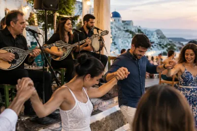 Mensen hand in hand dansend bij live bouzouki-band op terras met Grieks dorp op achtergrond